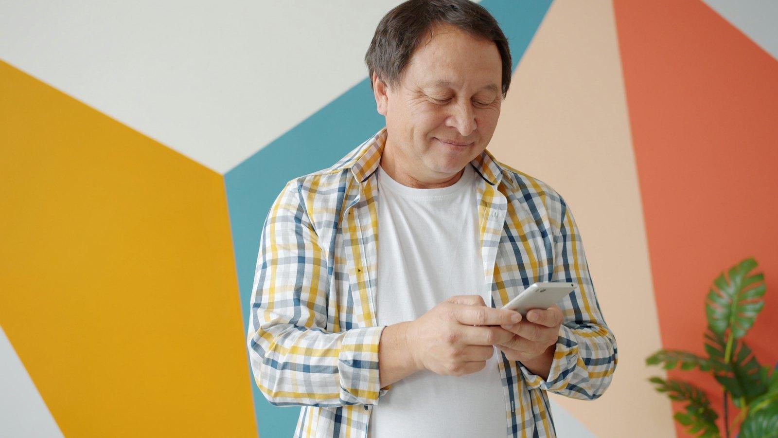 Man smiling at a text on his phone
